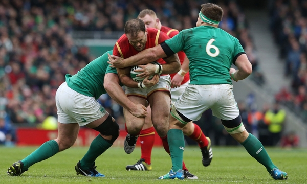 Jamie Roberts of Wales is tackled by Jack McGrath and CJ Stander