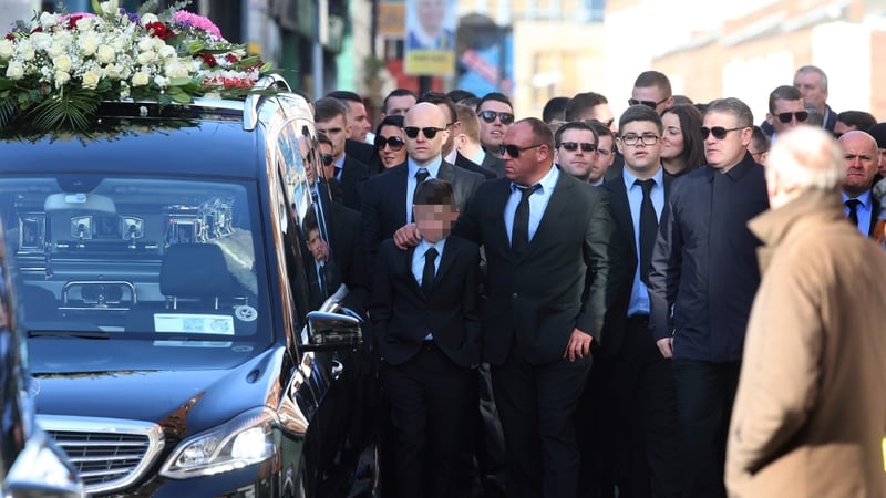 Mourners follow the hearse carrying the remains of David Byrne
