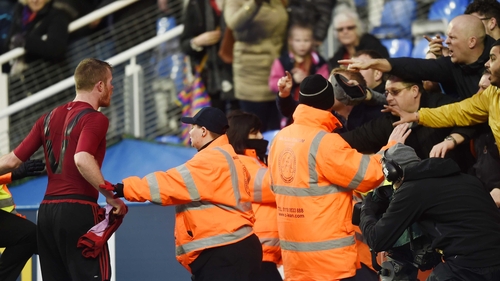 Chris Brunt reacts after being struck by a coin