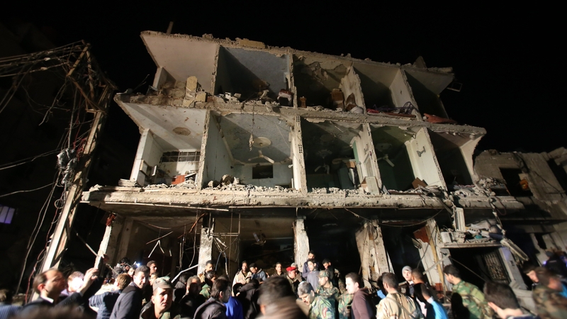 Syrians gather at the site of a series of attacks the area of the Sayyida Zeinab shrine