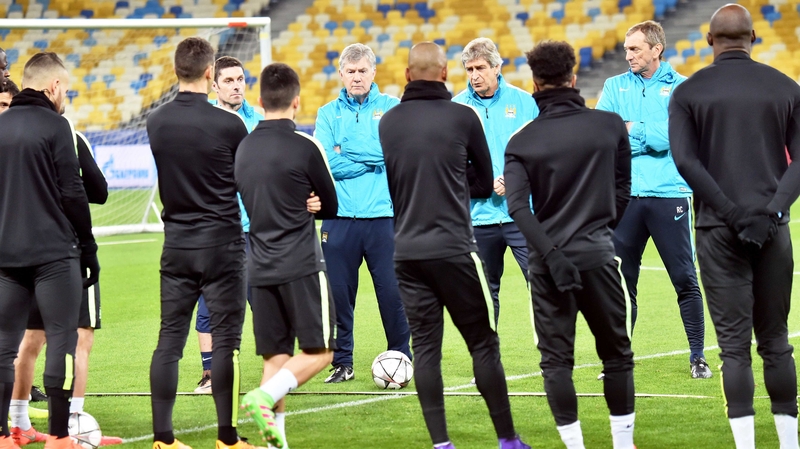 Man City players listen to boss Manuel Pellegrini at a training session in Kiev