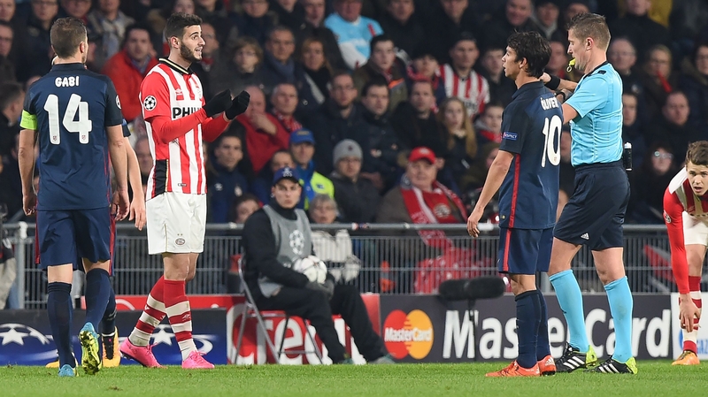 Referee Daniele Orsato prepares to give a red card to PSV Eindhoven's Gaston Pereiro