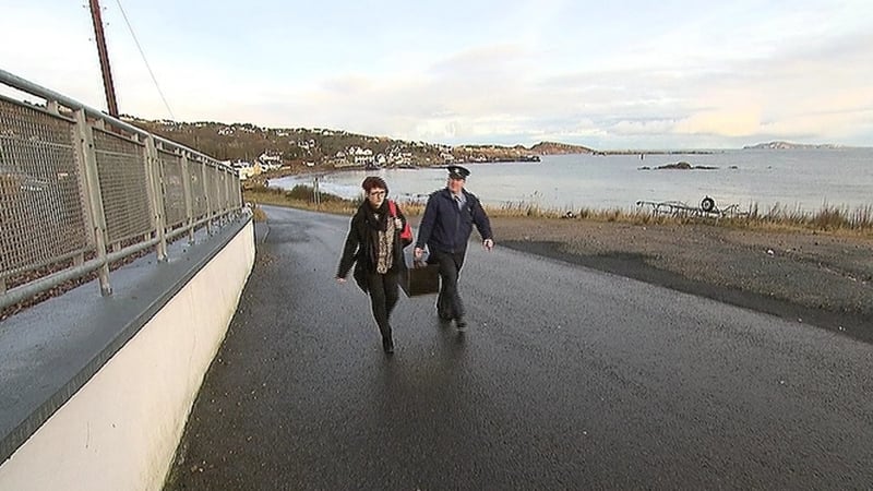 A Garda brings the ballot box to the polling station on Arranmore island