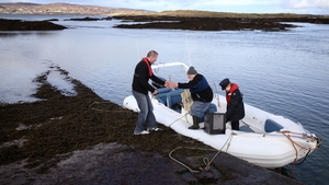 (L - R) Oscar Duffy, Hans Schleweck and Garda Margaret Byrne come off a boat transporting a ballot box on Inishfree Island, Co Donegal