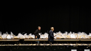 Officials walk past sealed ballot boxes at the RDS centre in Dublin