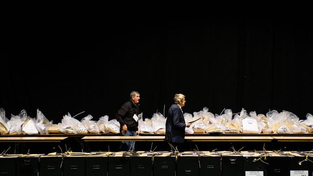 Officials walk past sealed ballot boxes at the RDS centre in Dublin