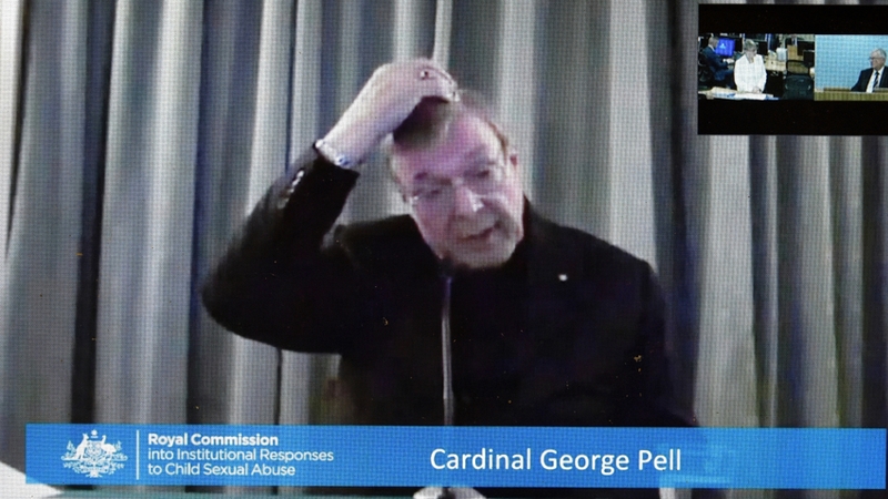 Cardinal George Pell is shown on a screen in Canberra, as he gives evidence to the commission via video link from Rome