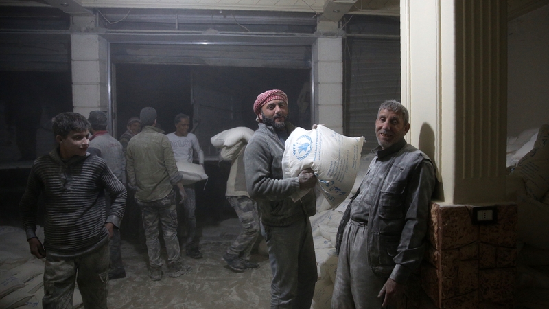 Syrians unload an aid delivery in the rebel-held town of Sabqa