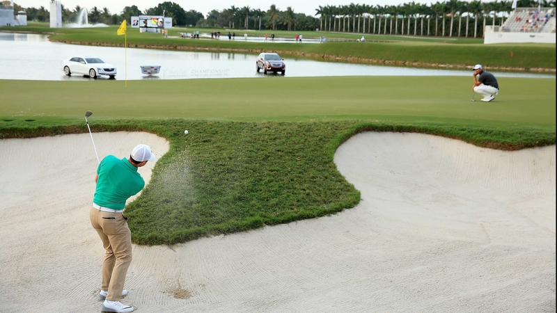 Rory McIlroy escapes from the bunker on 17