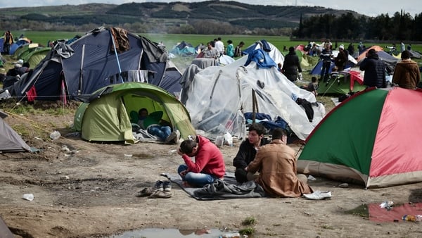People sit in a makeshift camp at the Greek-Macedonian borders