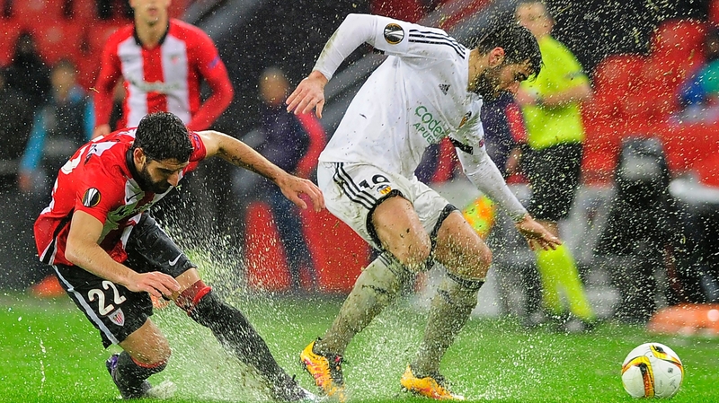 Athletic Bilbao midfielder Raul Garcia (L) vies with Valencia's Argentinian midfielder Enzo Perez on a soaked Estadio de San Mames pitch
