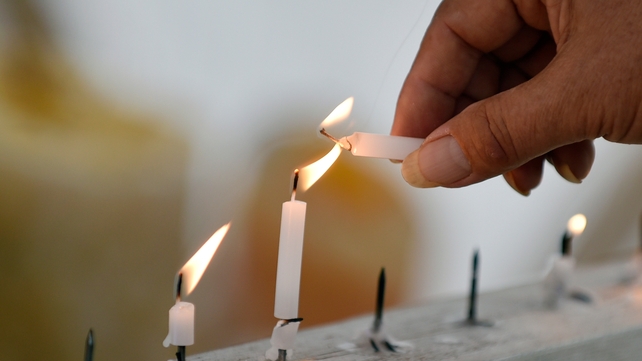 A man lights a candle in Tokyo during a remembrance event