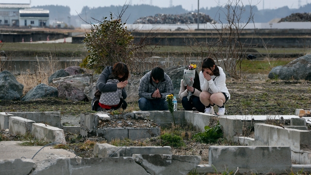 Toshiaki Fujita (2-L) offers a prayer for his late mother Toshiko, who was killed five years ago