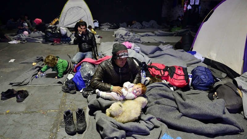 An Iraqi family rests in a warehouse at the port of Piraeus near Athens where thousands of refugees and migrants find temporary shelter