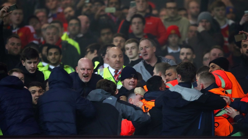 Fans are restrained by stewards at Old Trafford