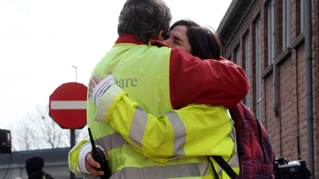 Airport staff comfort each other as passengers are evacuated from Zaventem Bruxelles International Airport
