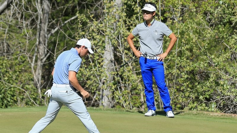 Rory McIlroy holes out as Kevin Na looks on at the WGC-Dell Match Play