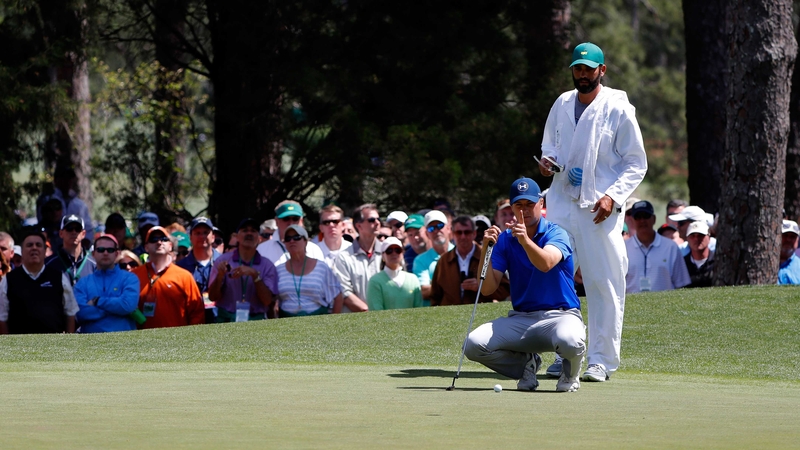 Jordan Spieth and caddie Michael Greller line up a putt on the sixth