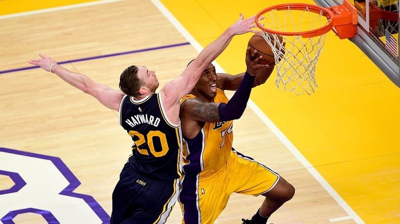 Kobe Bryant (R) of the Los Angeles Lakers goes to the hoop under pressure from Gordon Hayward of the Utah Jazz