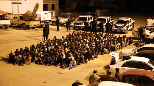 Migrants are stopped from attempting a Mediterranean crossing after a police raid on their hideout in Tripoli, Libya