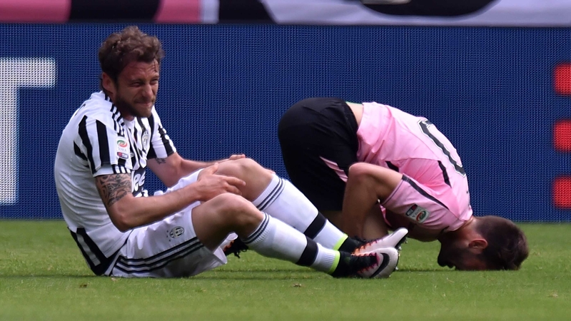 Claudio Marchisio clutches his left knee after falling awkwardly