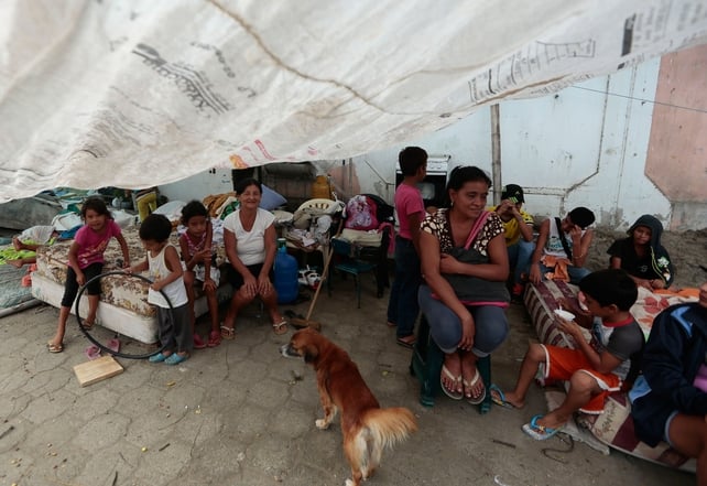 People rest in a temporary shelter in Bahia de Caraquez