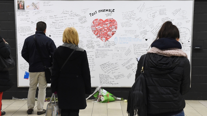 Passengers read messages on a commemorative wall at Maalbeek metro station