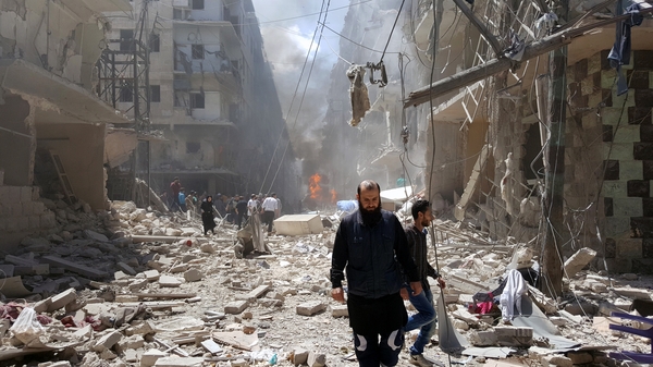 Syrians at the site of airstrikes in the rebel-held neighbourhood of Bustan Al Qasr in Aleppo