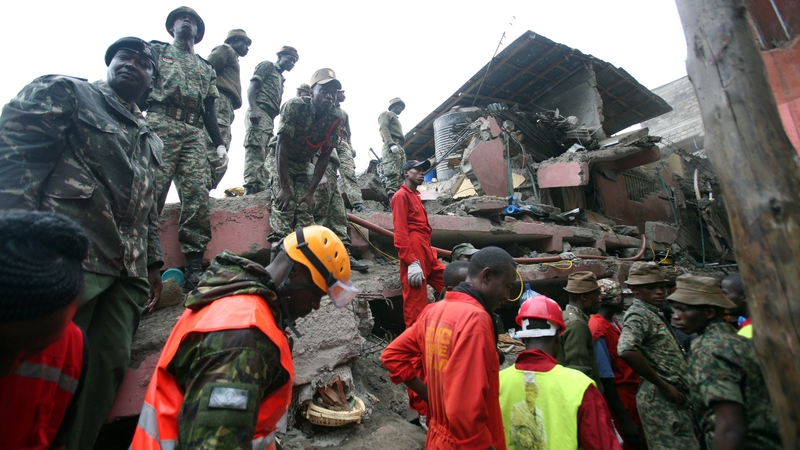 Military personnel and members of a rescue team sift through the rubble of the building in Nairobi