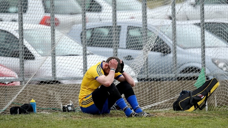 Roscommon goalkeeper Noel Fallon sits dejected on the ground after his team's defeat by Antrim