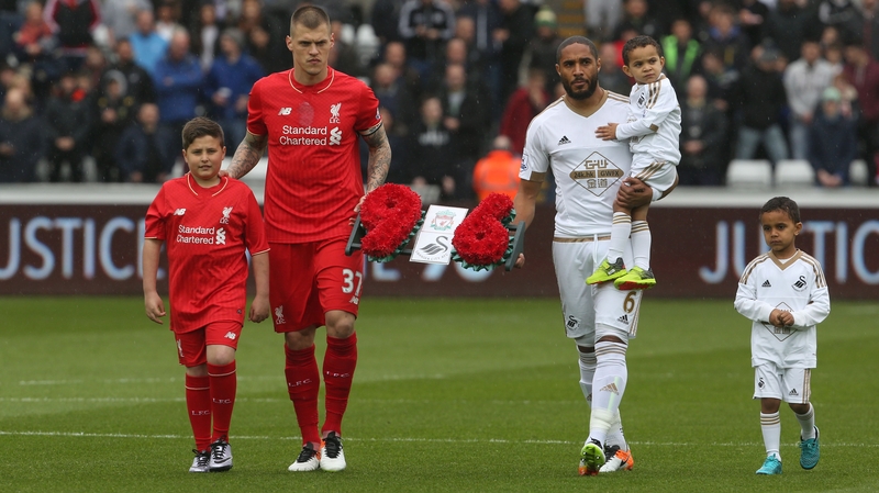 Liverpool captain Martin Skrtel and Swansea captain Ashley Williams (R) carry a wreath in memory of the 96 victims of the 1989 Hillsborough Distaster