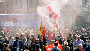 Protesters light a smoke flare at Trafalgar Square in London