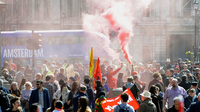 Protesters light a smoke flare at Trafalgar Square in London