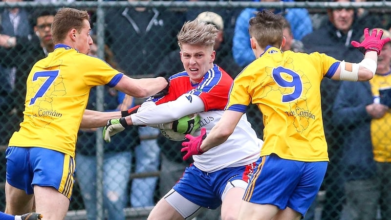 New York's Luke Loughlin runs with the ball while being pursued by Roscommon's Niall McInerney and Cathal Compton