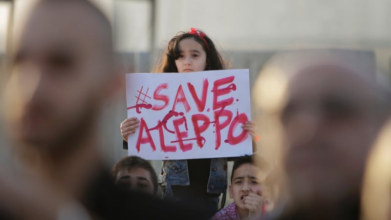 A Syrian girl holds a placard at a