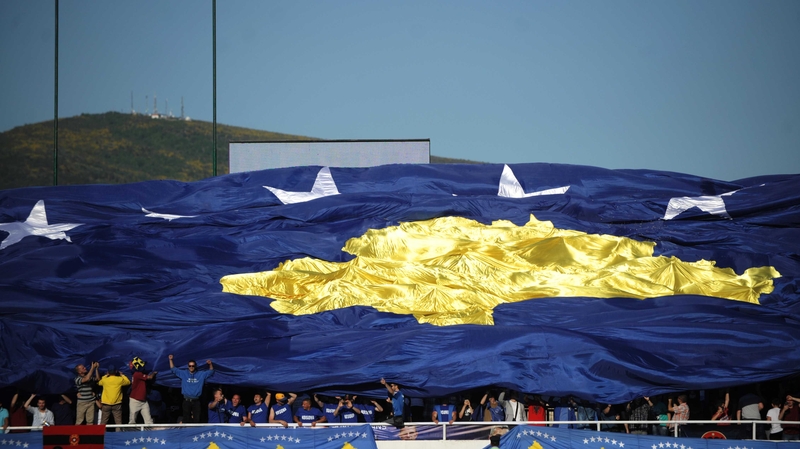 Kosovo supporters hold up a giant national football team flag