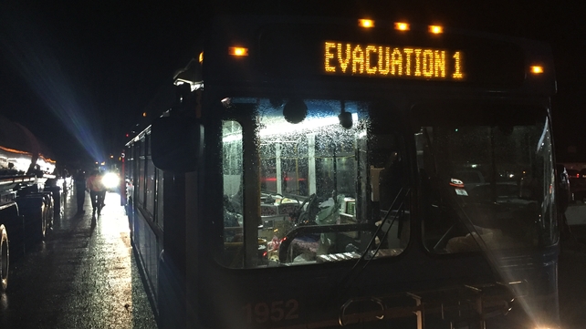 A bus evacuates people after all 88,000 residents were forced to flee