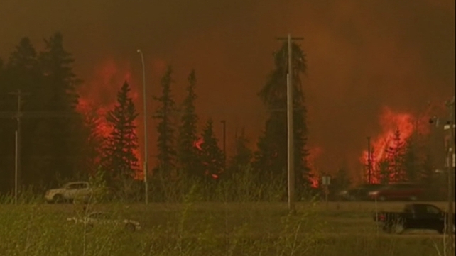 Worsening fire conditions pushed walls of flames towards thousands of homes in the northeastern Alberta town