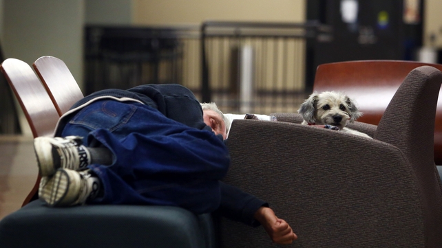 A man and his dog sleep on a makeshift bed at a recreational centre in Lac la Biche after fleeing the forest fires