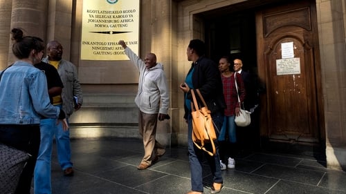 Former mine worker Vuyani Twadube (centre) celebrates as he leaves Johannesburg High Court after the judgement