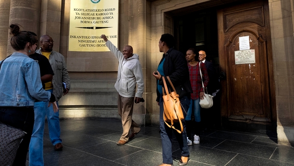Former mine worker Vuyani Twadube (centre) celebrates as he leaves Johannesburg High Court after the judgement