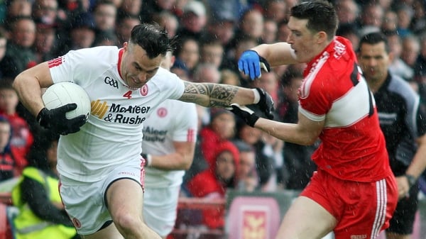 Tyrone's Cathal McCarron holds off Derry's Gareth McKinless