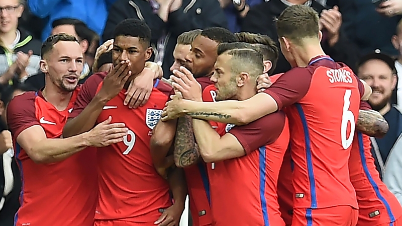 Marcus Rashford is mobbed by team-mates after his goal against Australia
