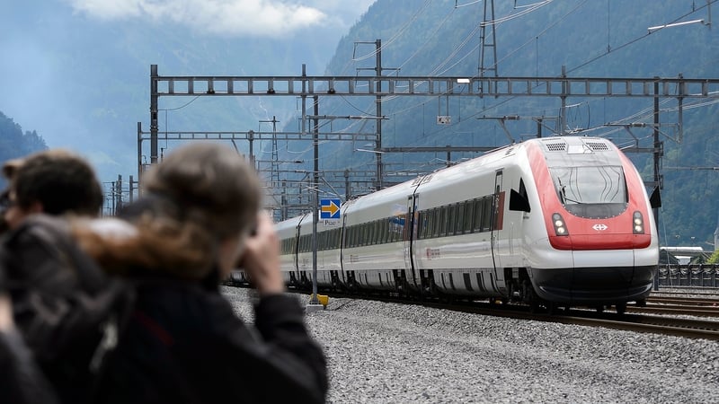 Guests who attended the opening ceremony of the tunnel take a picture of the first train crossing it