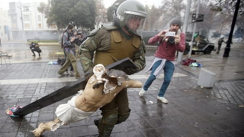Policeman recovers a cross taken from the National Gratitude Church during the protest