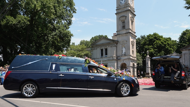 A hearse carrying the body of the late Muhammad Ali turns into Cave Hill Cemetery during his funeral procession in Louisville