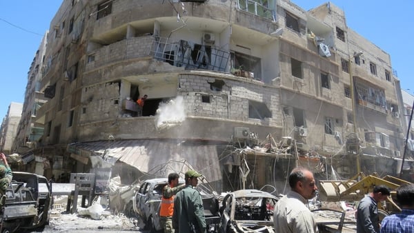 At least 20 people were killed and scores wounded in twin suicide and car bomb blasts in a Damascus suburb yesterday
