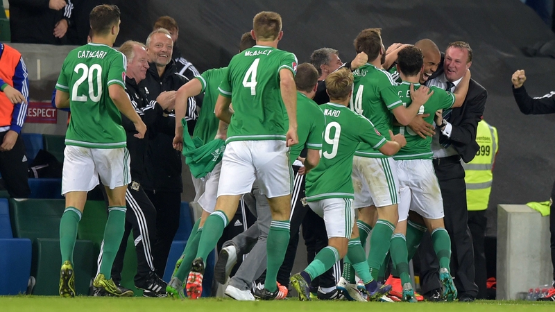 The players rush to celebrate with Michael O’Neill during the qualifier against Greece at Windsor Park