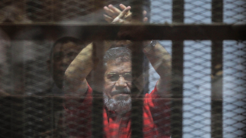 Ousted Egyptian President Mohammed Mursi looks on during a trial session on charges of espionage in Cairo, Egypt