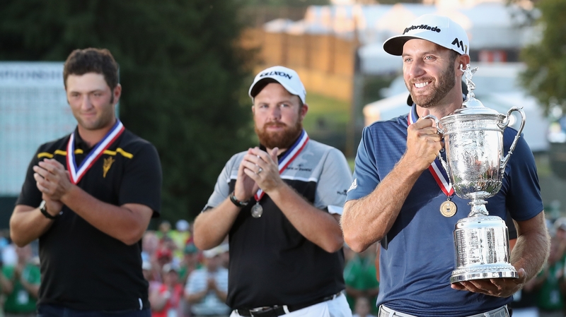 Dustin Johnson (R) poses with the US Open trophy after winning the US Open as Shane Lowry (C) and Amateur Jon Rahm (L) look on